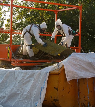 Asbestos abatement & cleanup with specialists wearing protective gear