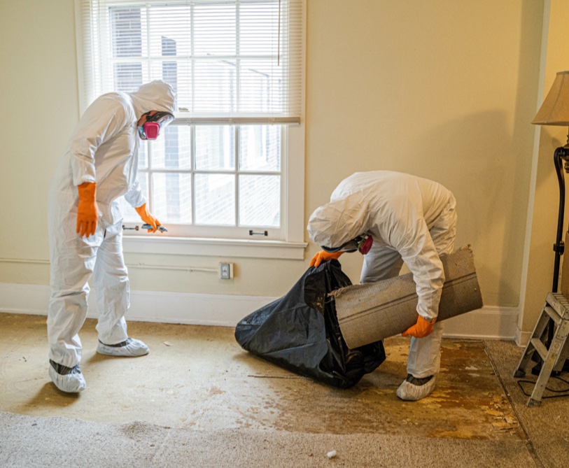 two professionals cleaning up and removing asbestos & flooring in home