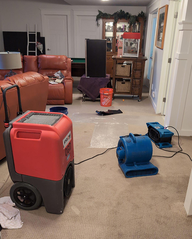 water damage restoration project with dryers and other flood cleanup equipment on wet carpet