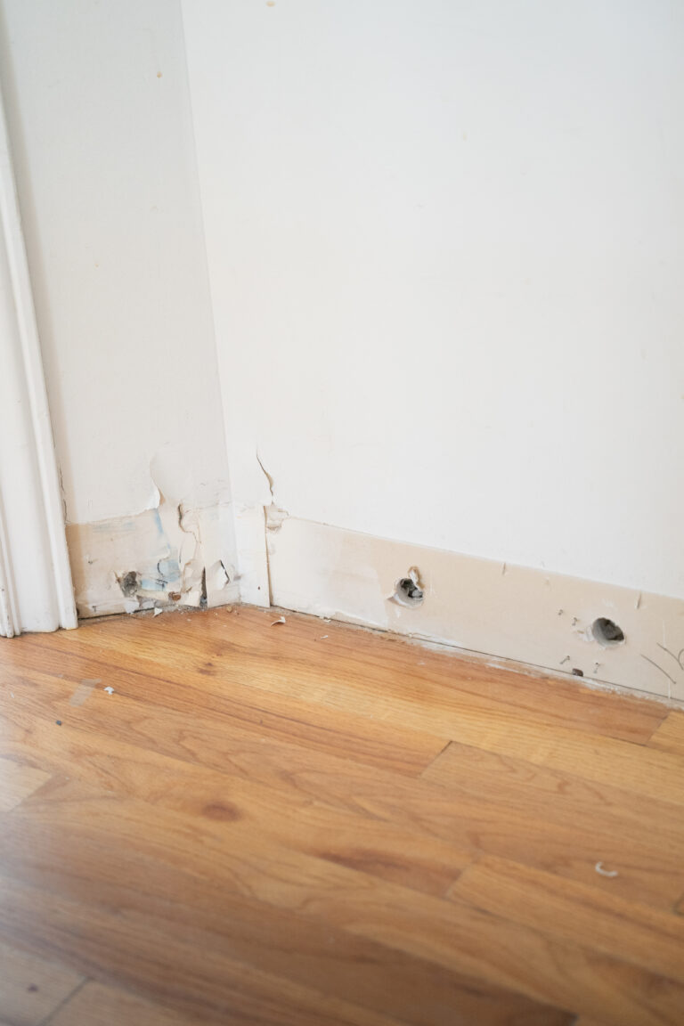 Row of small drilled holes along the base of a wall used to dry the wall cavity